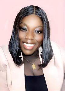 Portrait of Ursular Koranteng smiling, wearing a black top and light-colored jacket, with braided hair.